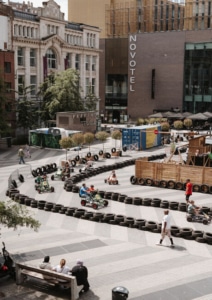 Circuit de cuistax délimité par des pneus sur la place Verte à Charleroi, avec des visiteurs qui participent, dans le cadre de l'événement Virages
