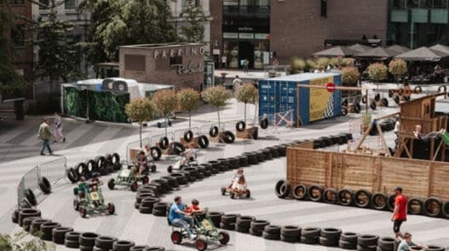 Circuit de cuistax délimité par des pneus sur la place Verte à Charleroi, avec des visiteurs qui participent, dans le cadre de l'événement Virages