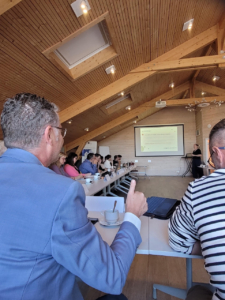 Participant levant le pouce pendant une présentation sur l'historique du projet Caroligne lors d'une réunion CROSS4MOBILITY