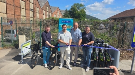 Inauguration de la station de vélos à assistance électrique Vélo Fluo à la gare de Revin, avec la coupe du ruban par les officiels.
