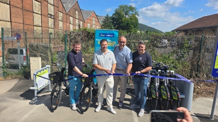 Inauguration de la station de vélos à assistance électrique Vélo Fluo à la gare de Revin, avec la coupe du ruban par les officiels.