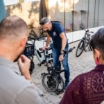 Démonstration d'un vélo pliant Brompton devant des participants.