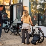 Participante essayant un vélo cargo électrique accompagnée d'un conseiller.