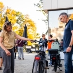 Participante découvrant le guidon d'un vélo électrique avec un conseiller Mobilesem.