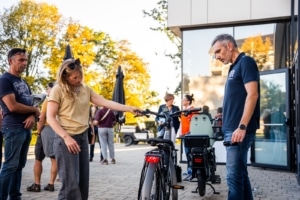 Participante découvrant le guidon d'un vélo électrique avec un conseiller Mobilesem.