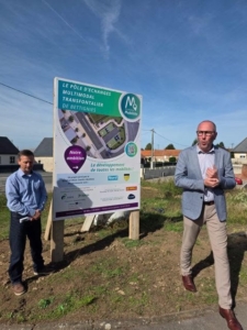 Deux hommes devant le panneau de chantier du futur Pôle d'Échanges Multimodal de Bettignies.