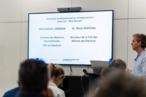 Écran annonçant l'ouverture et les mots d'accueil des Rencontres transfrontalières de l'Intermodalité, avec un intervenant s'adressant au public.